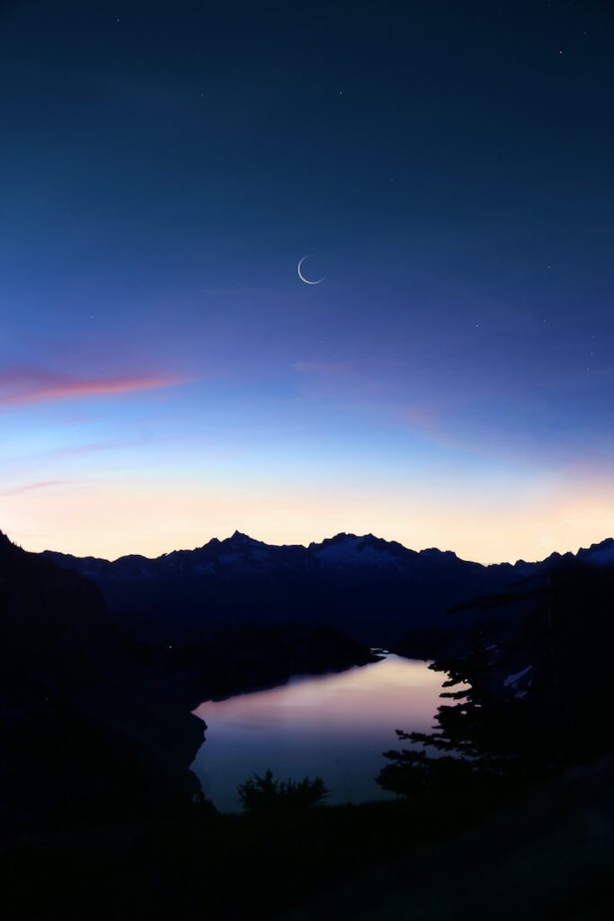 birds eye-view of lake under crescent moon